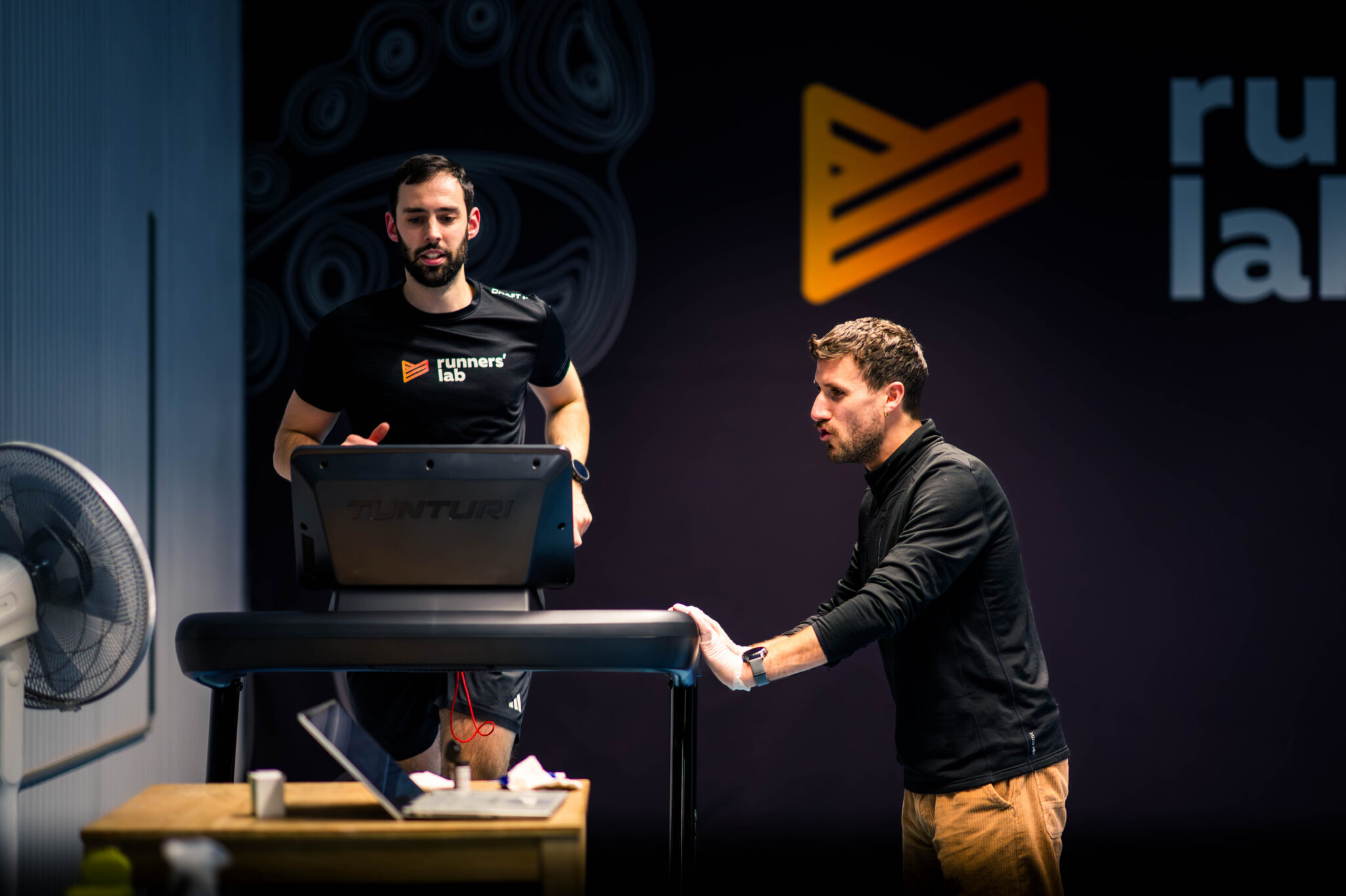 Loopcoach die atletenprestaties analyseert op de loopband
